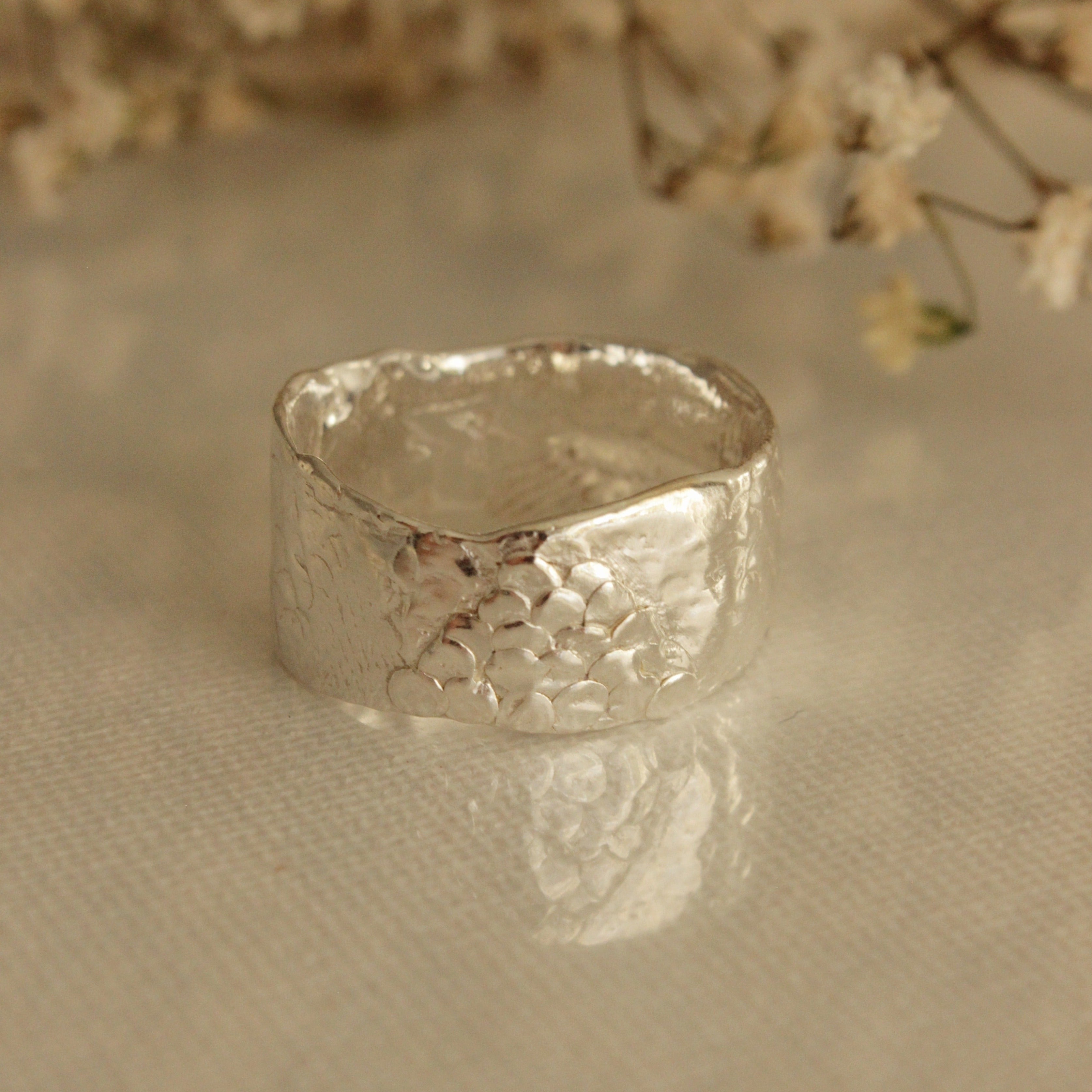 The Ancient Poet ring appears to have been plucked from the depths of the ocean. Scattered scales and hidden finger prints caress this organically formed band and offer a unique magic to this timeless piece. Enjoy this treasure everyday, along with the calming and tranquil effects it brings.