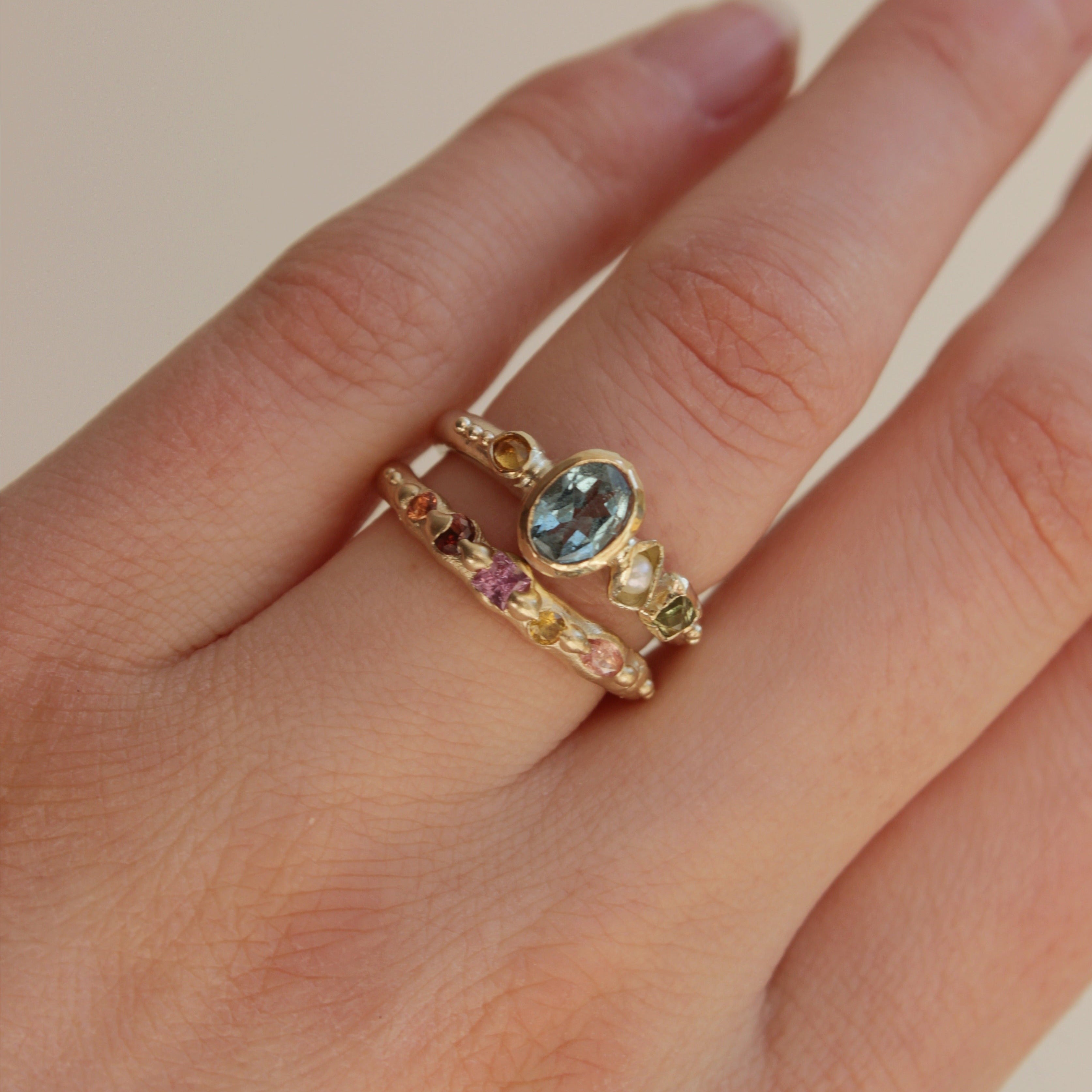 Bespoke, hand crafted 9ct gold alternative engagement ring. The ring features a vibrant oval Aquamarine, a pearl and sapphires. Handcrafted in Frome by Josie Mitchell Jewellery for the alternative bride and ocean lover. Worn with the Sapphire wedding band in 9ct gold.