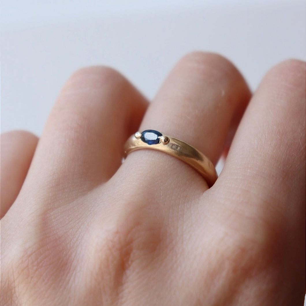 Deep blue sapphire on molten gold band
