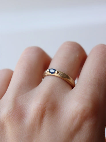 Deep blue sapphire on molten gold band