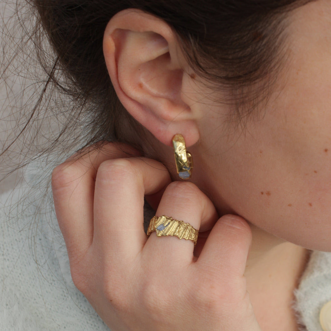Inspired by the Esme hoops from the new collection, These gorgeous brass earrings are delicate with hidden blue sapphires cast in place for an unearthed and organic finish.