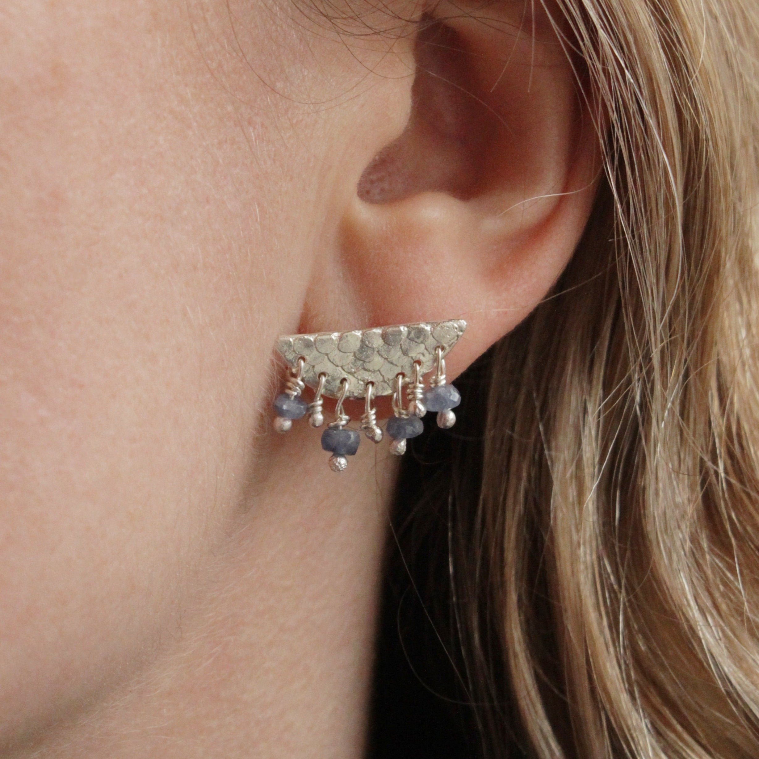 A fresh new take on the Manifest earrings from the Epiphany collection. These delicate studs feature intricate mermaid details and blue Sapphire beads that create a gorgeous movement when worn.
