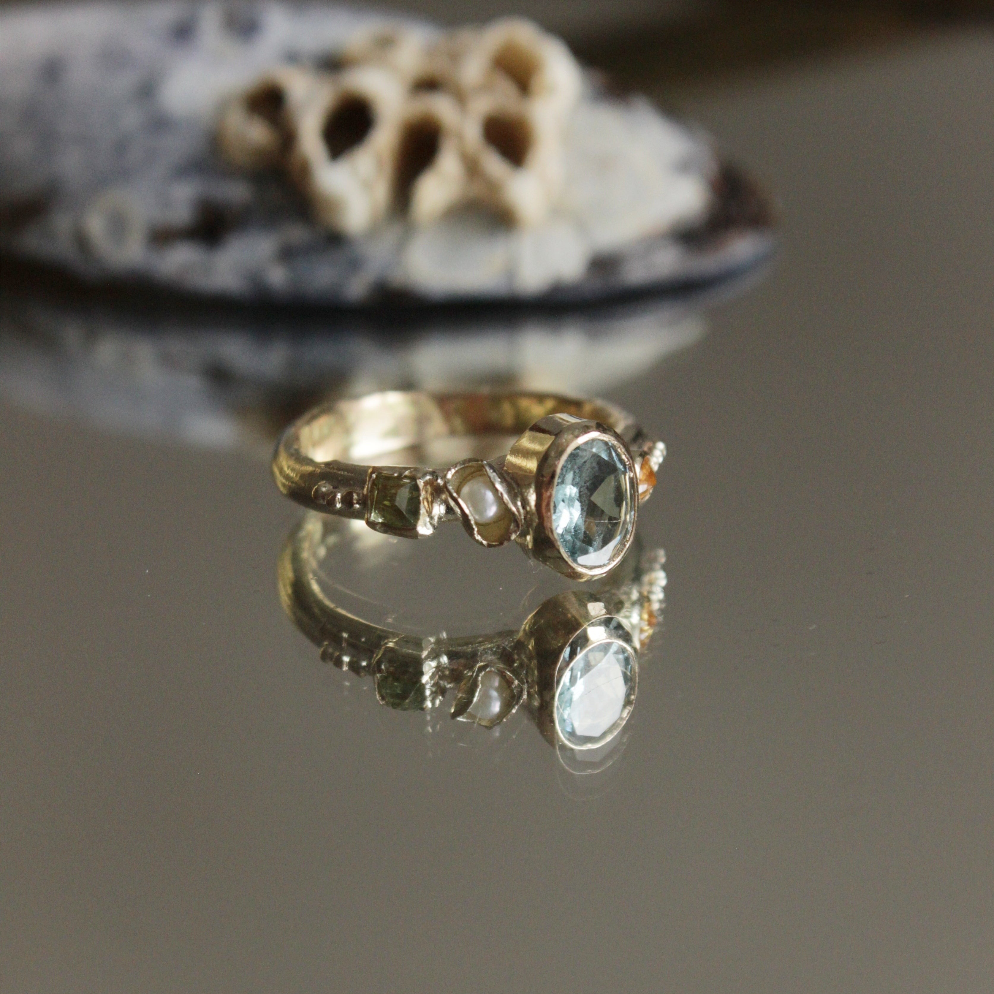 Bespoke, hand crafted 9ct gold alternative engagement ring. The ring features a vibrant oval Aquamarine, a pearl and sapphires. Handcrafted in Frome by Josie Mitchell Jewellery for the alternative bride and ocean lover.