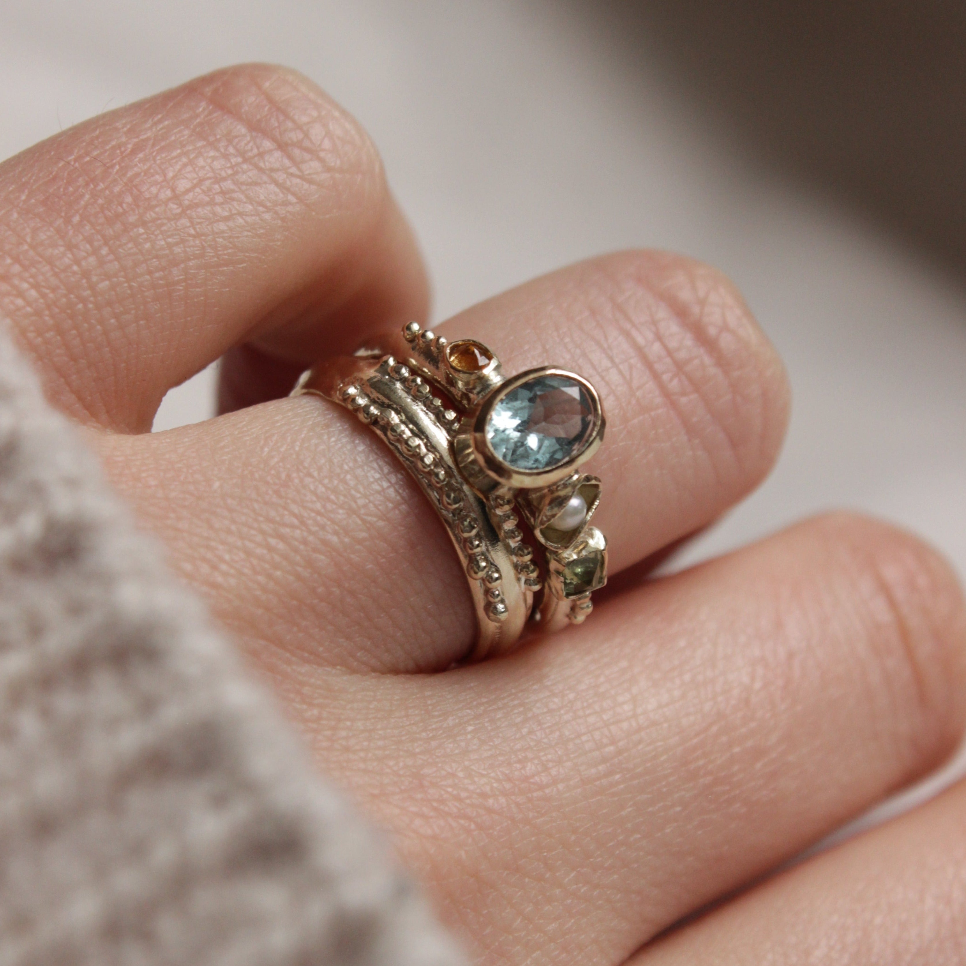 Bespoke, hand crafted 9ct gold alternative engagement ring. The ring features a vibrant oval Aquamarine, a pearl and sapphires. Handcrafted in Frome by Josie Mitchell Jewellery for the alternative bride and ocean lover. Worn with the Ancient wedding band.