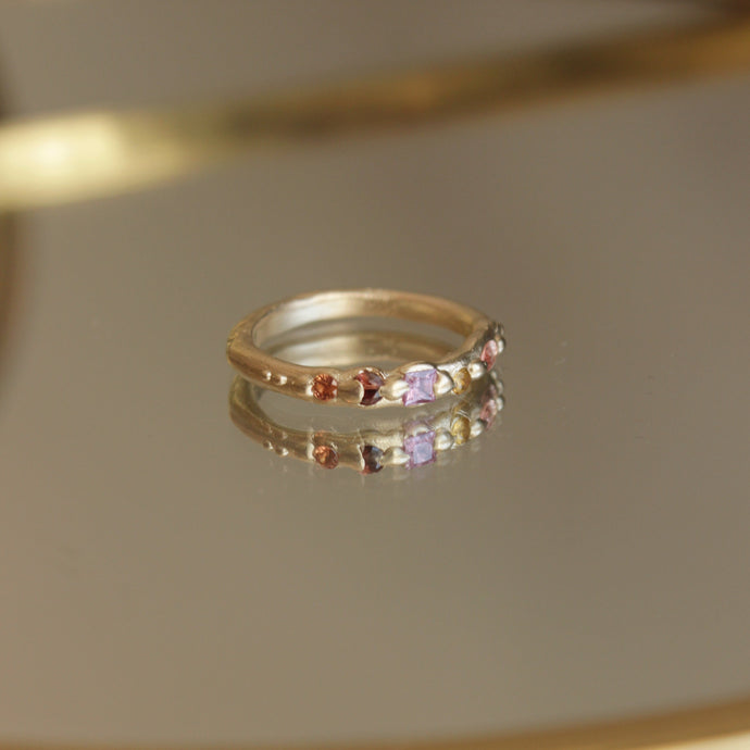 Stunning Sapphire wedding band for the alternative bride looking for a colourful option. The ring features 5 colourful sapphires in a array of colours ranging from peachy pinks to honey yellow. This ring is one of a kind and can be made in a variety of colour ways and stone options. Please contact Josie to discus the options.