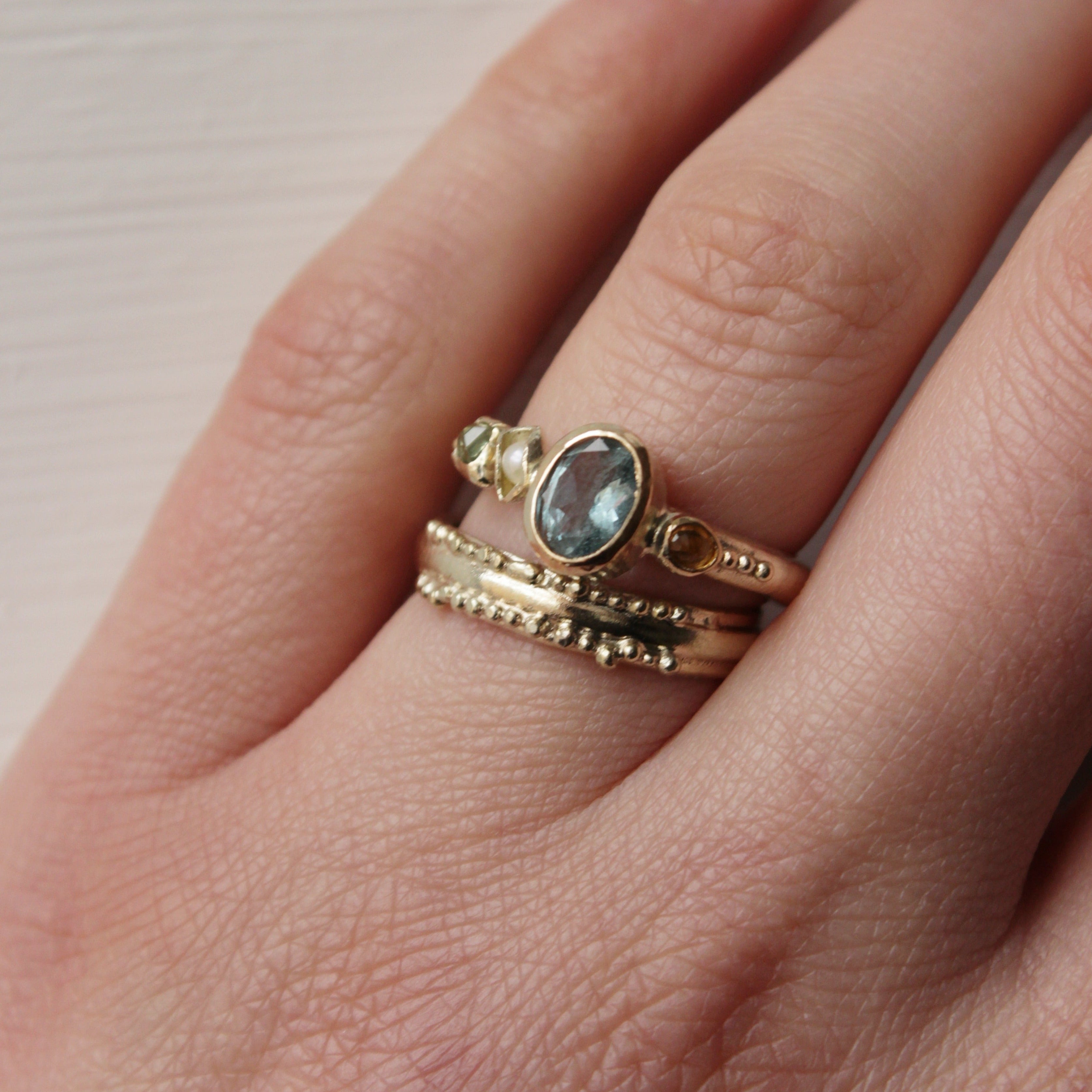 This stunning wedding ring is perfect for the alternative bride looking for an extra special wedding band. Inspired by ancestral metalsmithing techniques, this ring featured delicate granulation details that capture the light beautifully. Worn with the aquamarine engagement ring.
