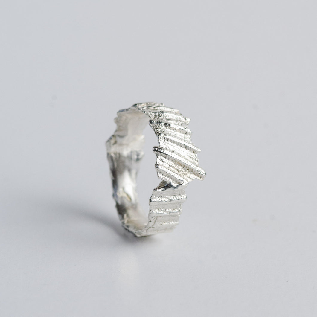 The Kratos ring is hand crafted by Josie Mitchell Jewellery using the ancient form of lost wax casting to create an unearthed and organic texture. Inspired by oceanic texture, the ring features a shell imprint and looks as though it has been plucked from the depths of the sea.