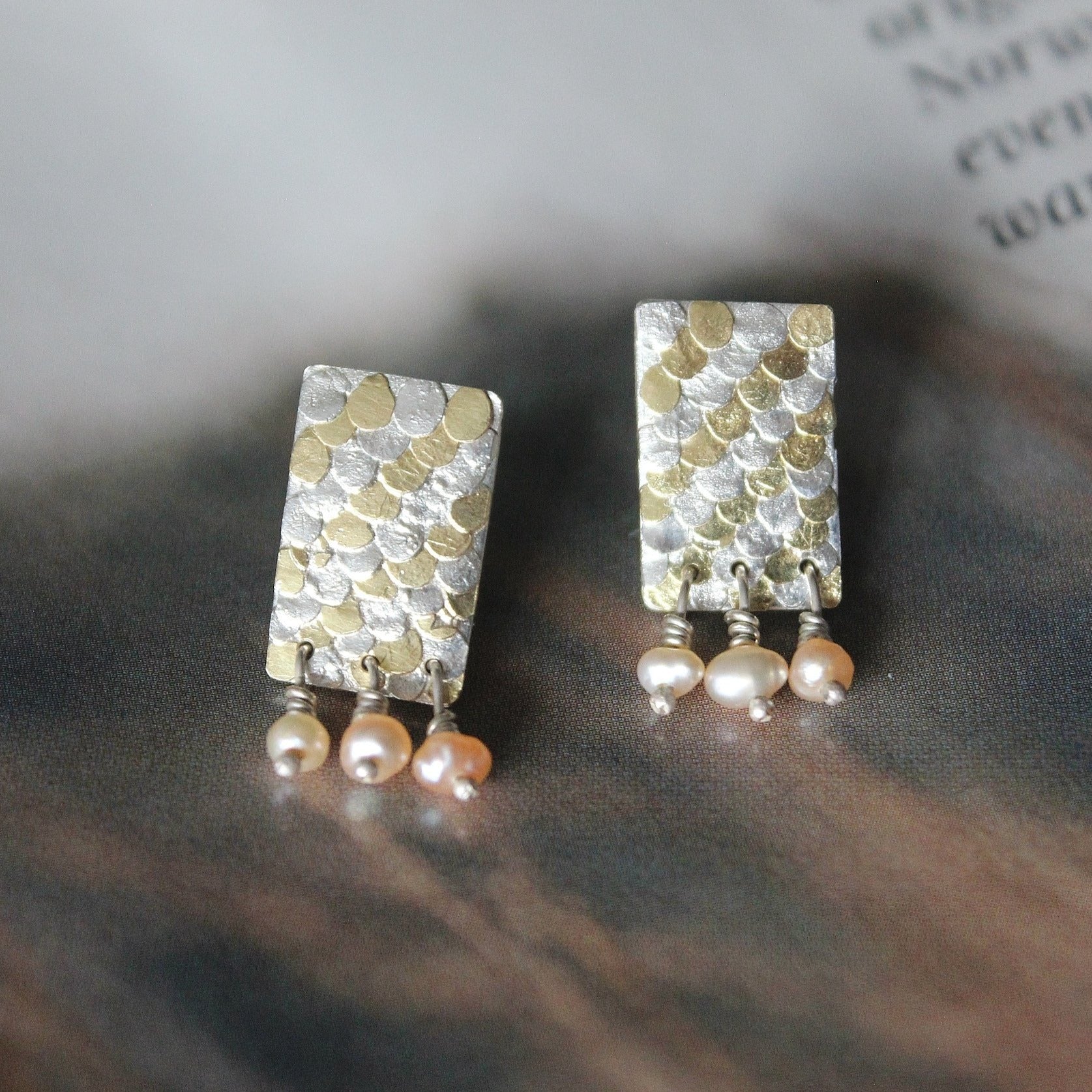 The Siren studs have been mindfully designed by Bournemouth based, Josie Mitchell jewellery, to be lightweight with luxurious, delicate details. Hand forged silver and 18ct gold scales are layered up to create a wonderful mermaid texture along with delicate pink fresh water pearls for a timeless and special pair of earrings.